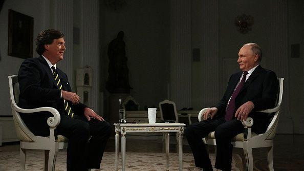 In this pool photograph distributed by Russian state agency Sputnik, Russia's President Vladimir Putin gives an interview to US talk show host Tucker Carlson at the Kremlin in Moscow on February 6, 2024.  