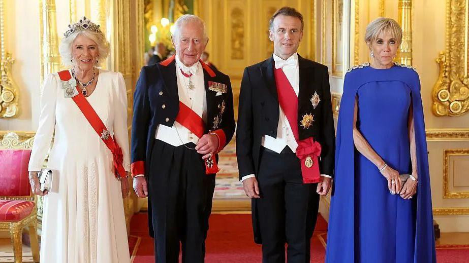 Kraljica je bila u svilenoj večernjoj haljini boje slonovače i krepa. Odevnu kombinaciju upotpunila je tijarom, narukvicom i minđušama od safira i dijamanata. Nakit je deo safirne kolekcije kraljice Elizabete II.