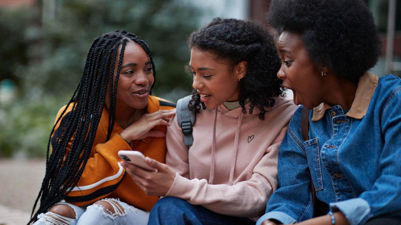 Tri mlade žene sede i pričaju