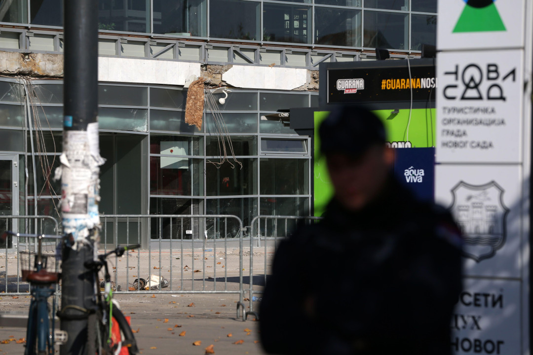 Silueta policajca u mraku a iza njega zgrada železničke stanice sa koje je otpala nadstrešnica