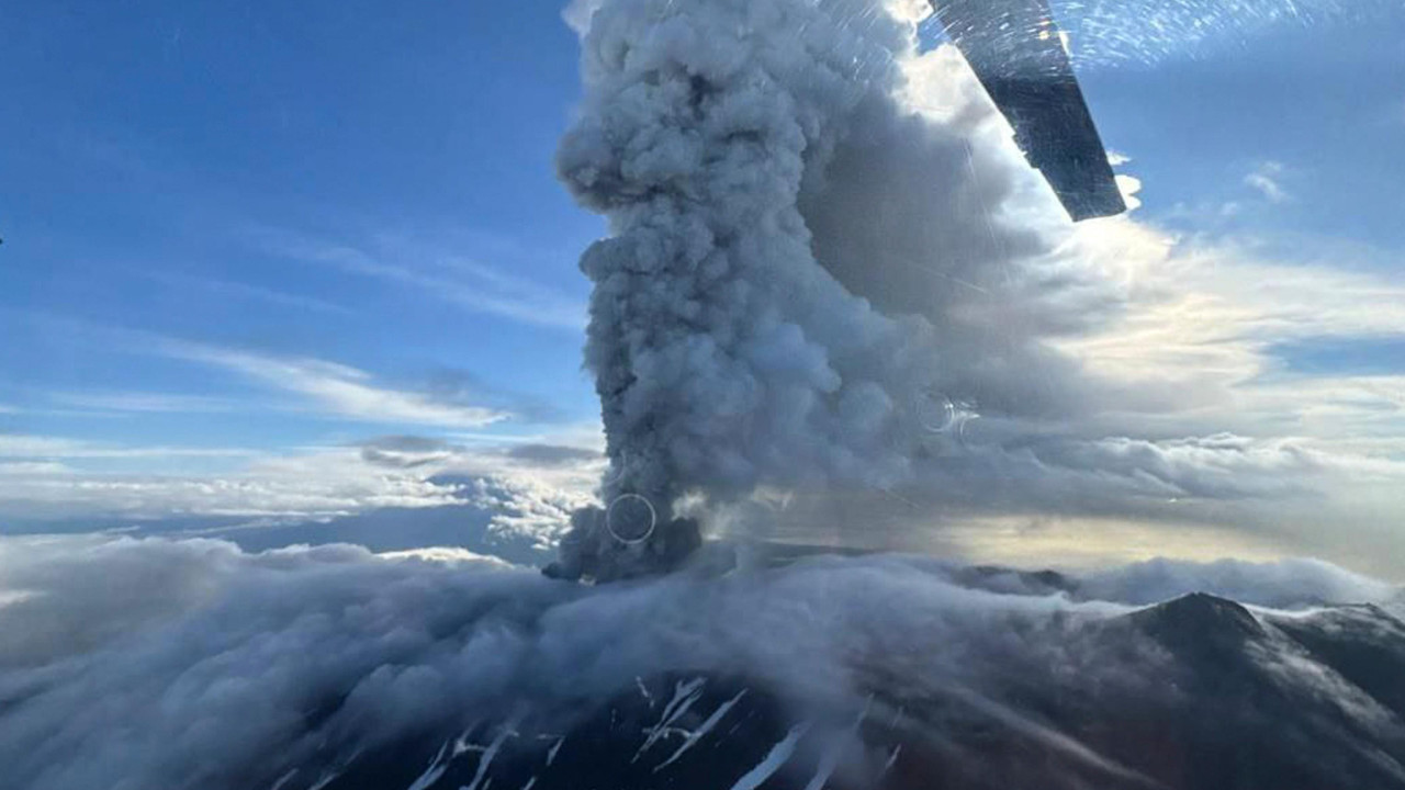Veliki oblak pepela uzdiže se iznad vulkana. Fotografija je, izgleda, snimljena iz helikoptera jer su lopatice rotora u prvom planu.