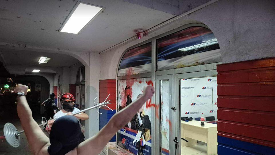 Dva muškarca ispred razbijenih prostorija SNS-a u Novom Sadu 