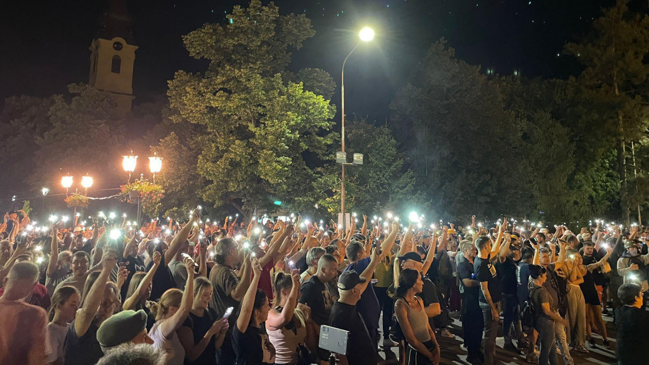 Ljudi drže svetla telefona u mraku