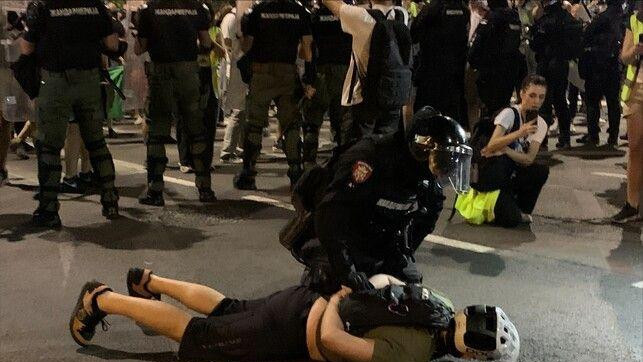 Momak sa kaciom leži na zemlji, a drži ga policajac