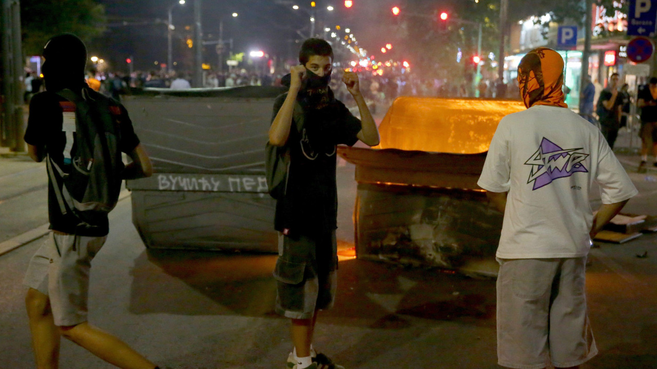 Tri momka prekrivenih lica ispred kontejnera 