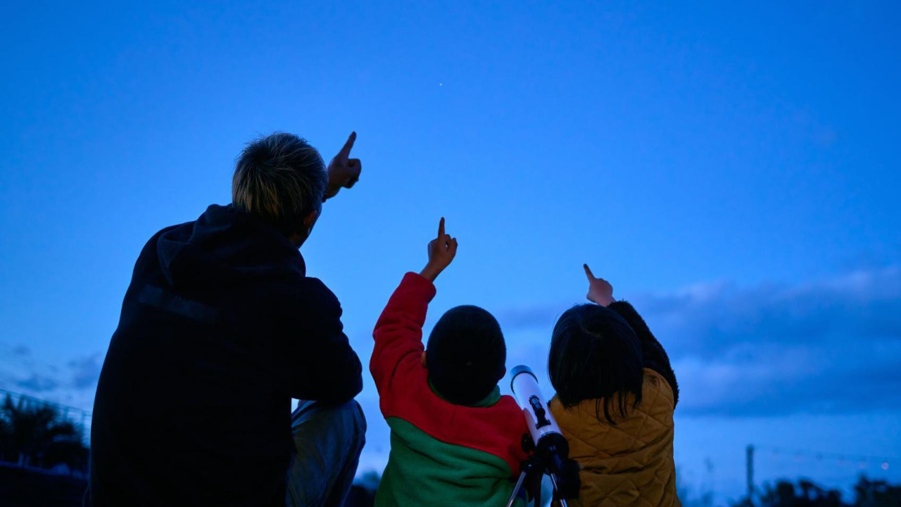 stariji čovek i deca gledaju u nebo 