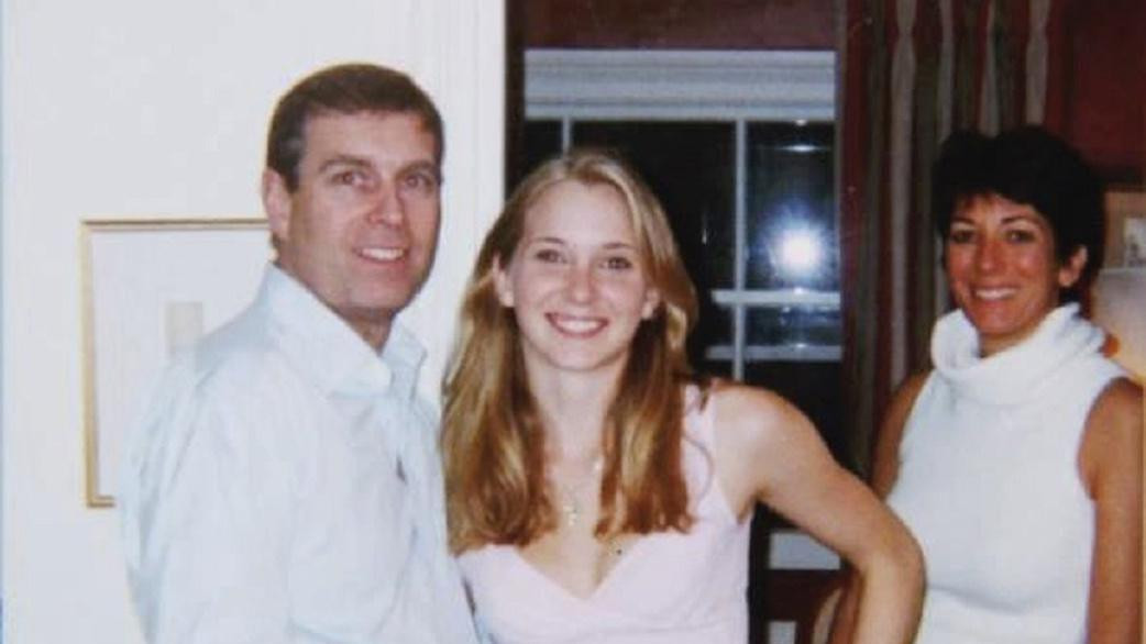 Stara fotografija princa Endrjua - obučenog u belu košulju raskopčanu na kragni - kako se smeši dok ruku drži na struku Virdžinije Đufre, mlade žene sa dugom plavom kosom, dok Gislena Maksvel stoji malo sa strane.