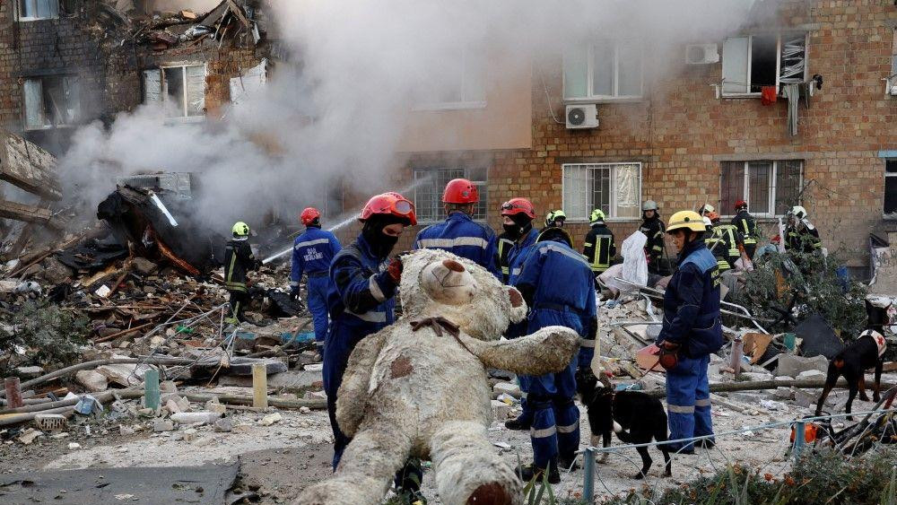 ruski napad na kijev, spasioci nose velikog plišanog medveda