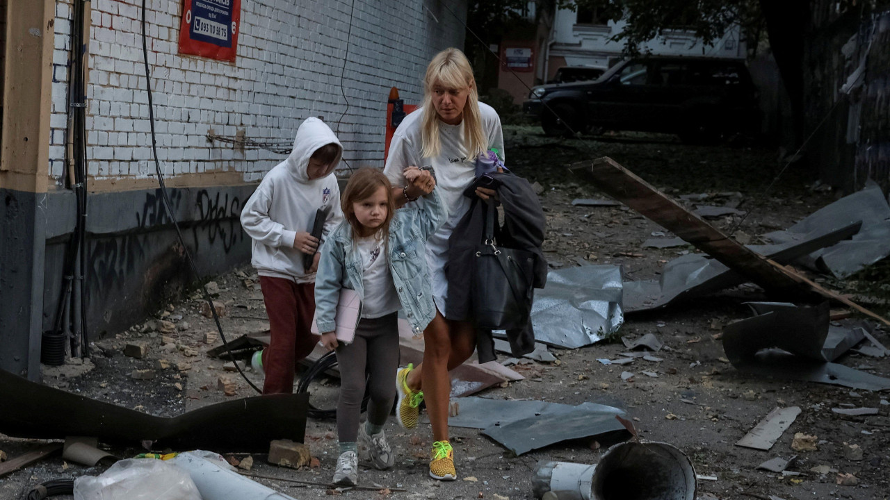 ruski napad na Kijev, ćena sa dvoje dece hoda među ruševinama posle ruskog napada na Kijev