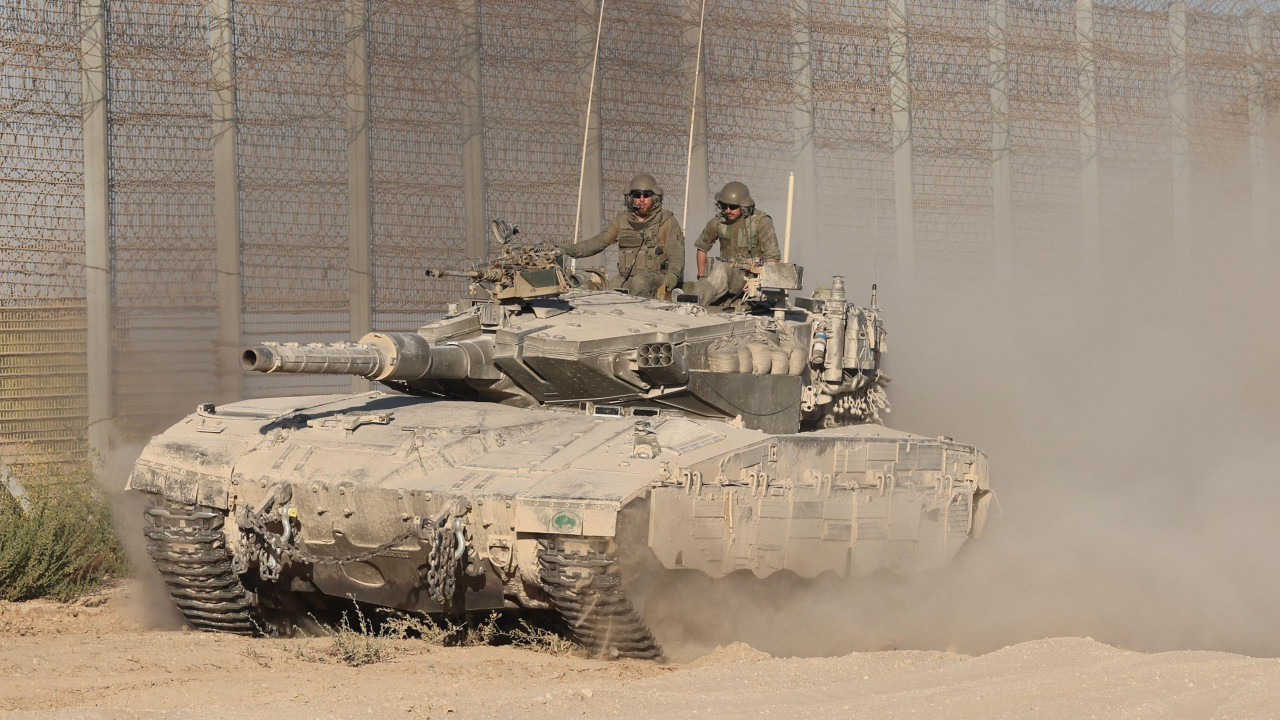 Izraelski tenk sa dvojicom vojnika prolazi pored ojačane ograde.