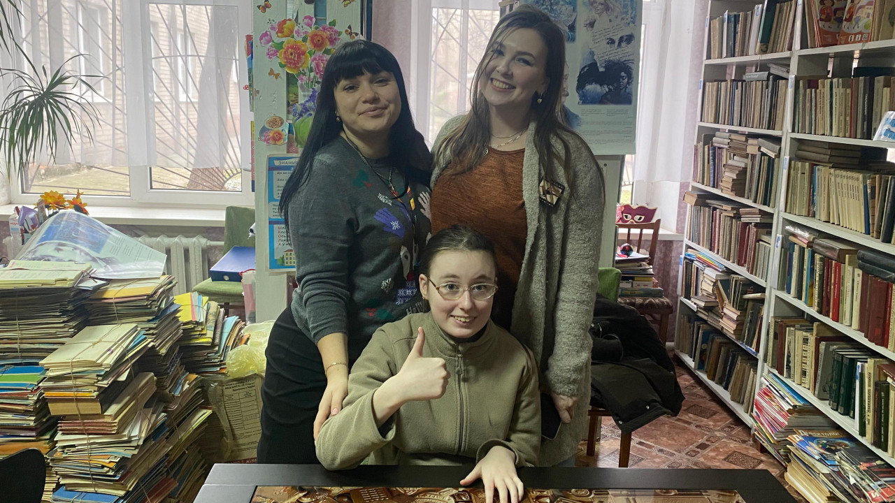 Jeva Pavlova sedi, a dve žene stoje i drže je za ramena