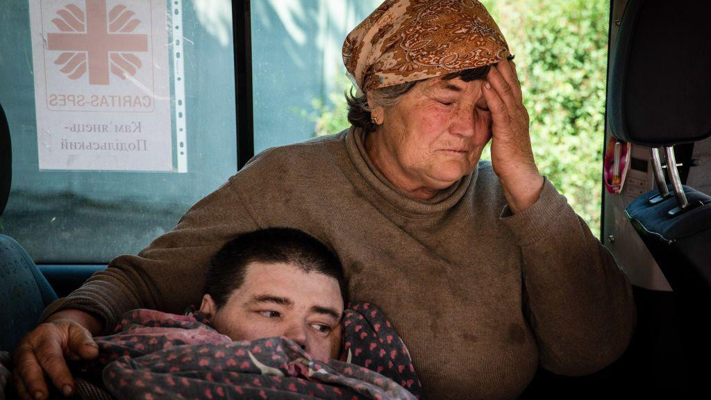 Majka plače uz sina koji leži i pokriven je ćebetom u Bahmutu