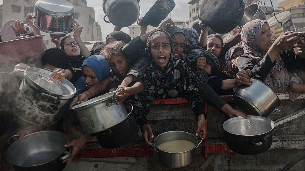 Žene u Gazi u rukama drže lonce sa hranom čekajući pomoć