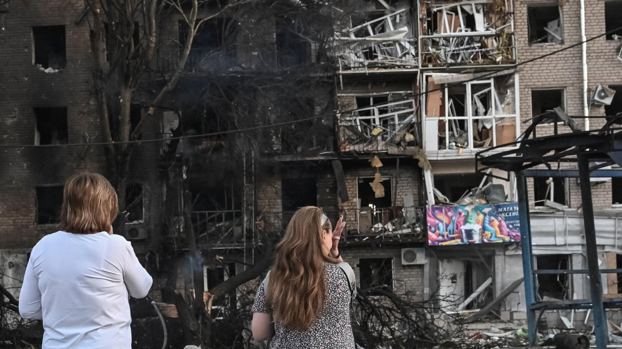 Residents stand at the site of an apartment building hit during a Russian drone and missile strike, amid Russia's attack on Ukraine