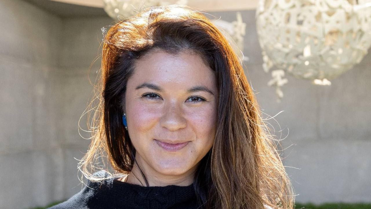 žena sa dugom braon kosom se osmehuje u kameru