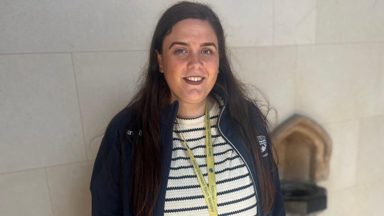 devojka u jakni i džemperu gleda u kameru