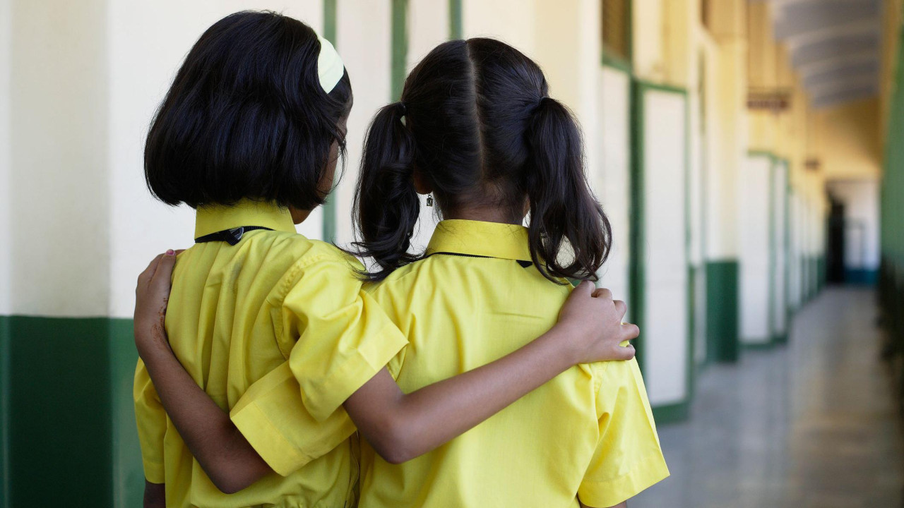 Dve učenice stoje zagrljene 