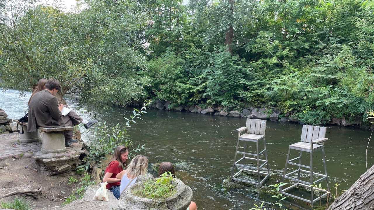 Posetioci Užupisa kraj reke Vilije, a tu su i umetničke postavke u vidu dve spasilačke stolice