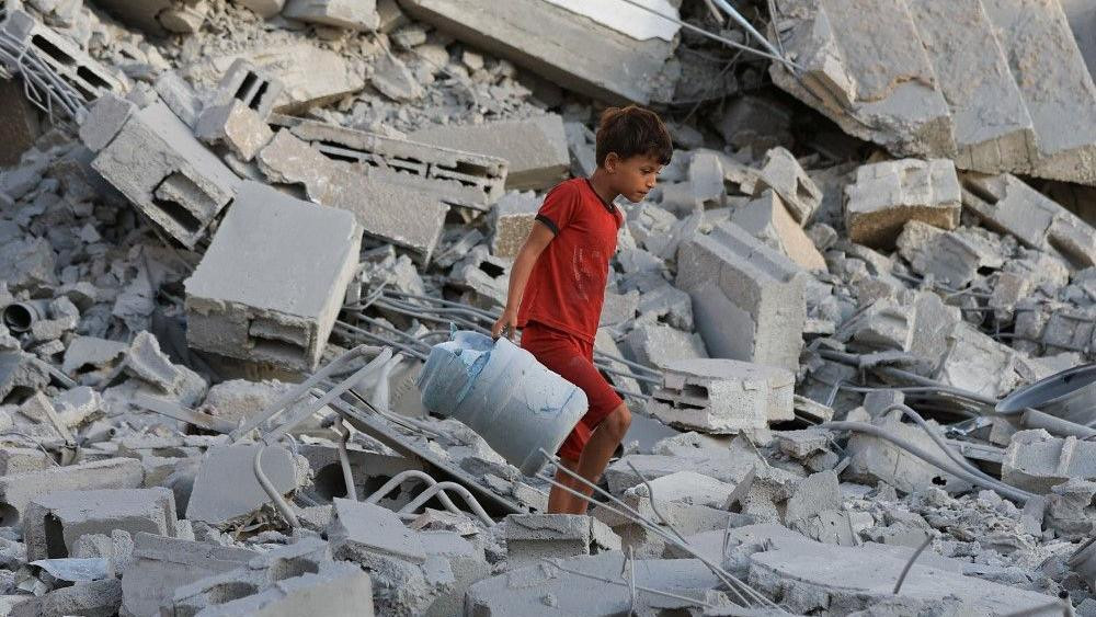 Palestinski dečak tumara po ruševinama jednog od mnogih pogođenih objekta u gradu Gazi