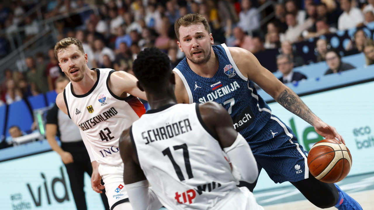 Luka Dončić u napadu, dok ga juri Andreas Obst, a ispred njega postavlja nemački kapiten Denis Šreder