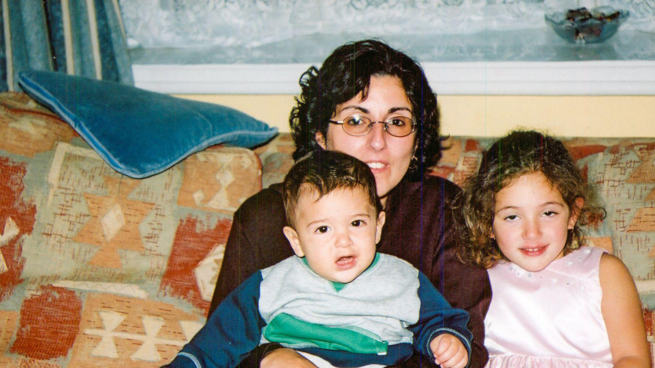 Sara sedi na krevetu sa sinom u naručju i ćerkom pored nje