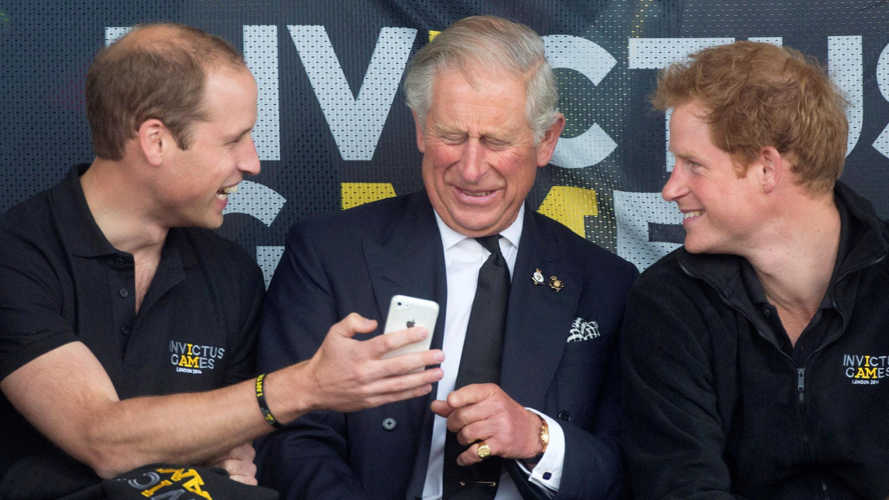 princ vilijam, kralj čarls, princ Hari, britanski prinčevi Vilijam (levo), Čarls (srednje) i Hari gledaju u mobilni telefon tokom Igara Nepokorenih