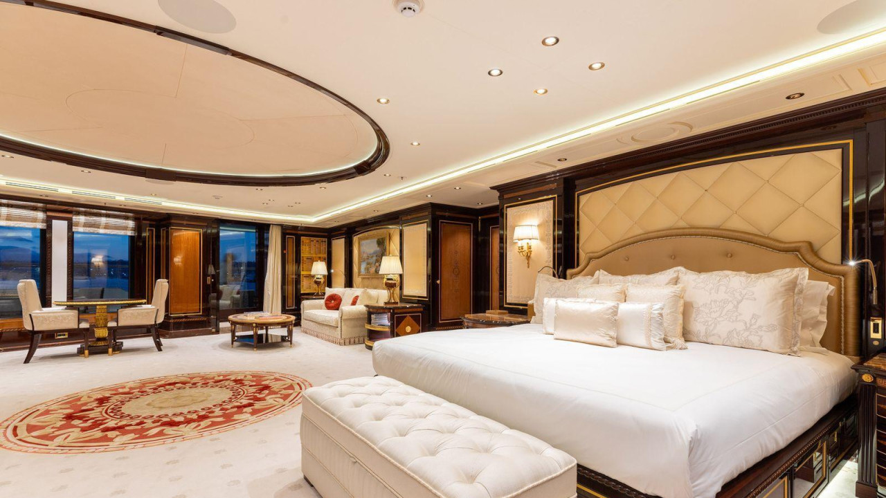 Krevet sa nekoliko jastuka nalazi se na desnoj strani sobe, sa pravougaonim tapaciranim sedištem bez naslona u podnožju kreveta. Na podu je svetlo smeđi tepih sa crvenim uzorkom. Pored prozora je trpezarijski sto sa dve stolice, kroz koji se vidi kopno uveče.