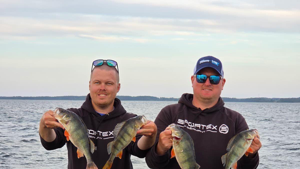 Toms Klabis i Gatis Ernstsons na čamcu drže ribe u rukama