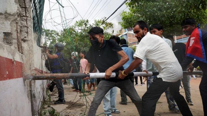 muškarci probijaju zid sa dugačkom metalnom cevi