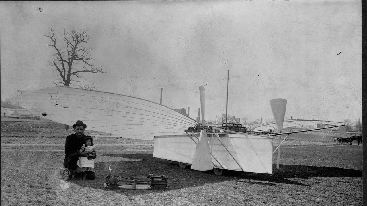 An old photograph of Gustav Weisskopf sitting next to an early plane model