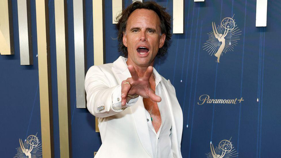 Zvezda filma „Beli lotos“ Volton Gogins u crnim pantalonama i belom sakou