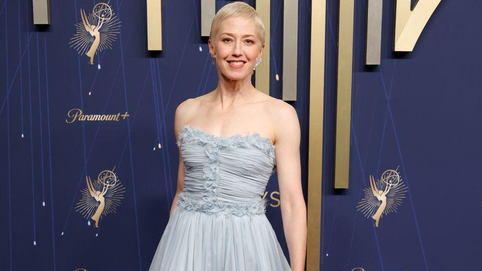 Keri Kun iz serije „Beli lotos“ u sivoj dugačkoj haljini