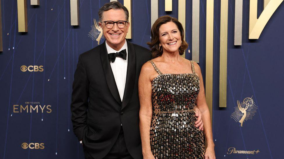Voditelj emisije „The Late Show“ Stiven Kolbert  u crnom odelu sa suprugom Evelin Mekgi-Kolbert u svetlucavo sivoj haljini
