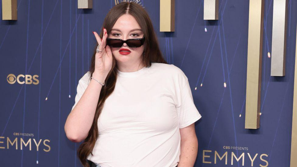 Megan Stalter u farmericama i beloj majici 