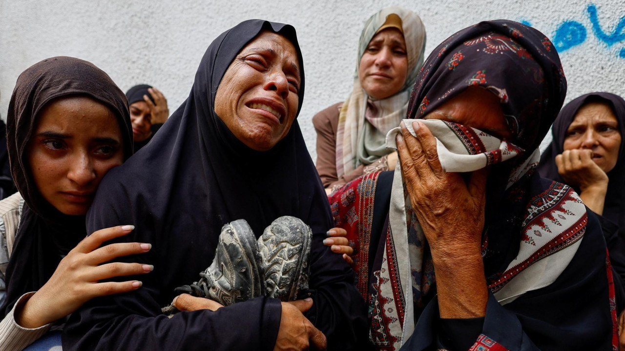 
                    File photo showing the mother of Palestinian teenager Khaled al-Shinbari holds his shoes during his funeral at al-Shifa hospital, in Gaza City, northern Gaza (28 August 2