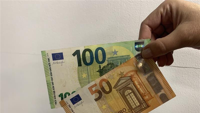 Ruka drži novčanice od 100 i 50 evra