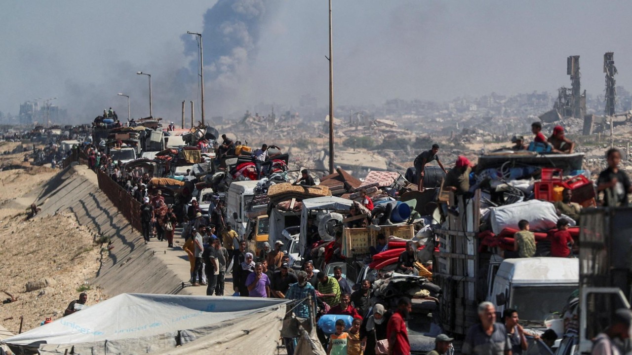 Smoke rises from an Israeli strike as displaced Palestinians flee northern Gaza, in the central Gaza Strip (14 September 2025)