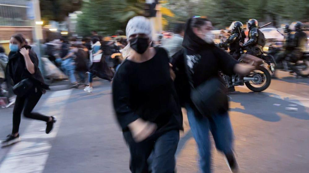 Zamućena fotografia devojaka na protestu, prekrivenog lica