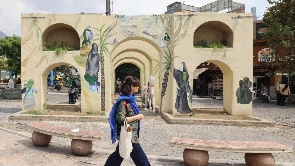 Žena šeta po gradu, noseći maramu oko vrata