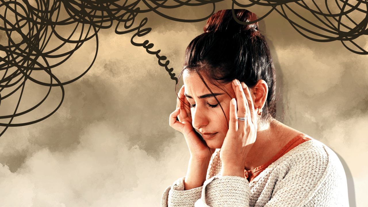 Žena drži glavu rukama u beloj majici i sa skupljenom crnom kosom, deluje pod stresom 