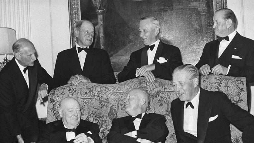 Crno-bela fotografija na kojoj su Vinston Čerčil, Ajzenhauer, premijer Herold Mekmilan. Njih trojica sede. Iza njih stoje drugi zvaniočnici