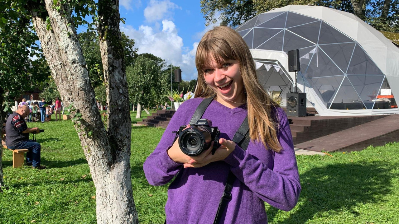 Aneta u ljubičastom džemperu sa foto-apartom u ruci