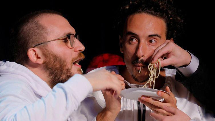 Dva muškarca jedu pastu na bini