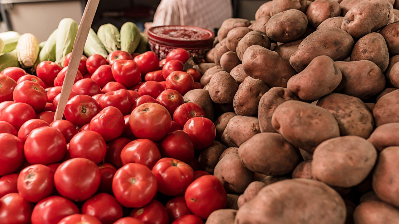 Krupni plan paradajza i krompira položenih na pijaci
