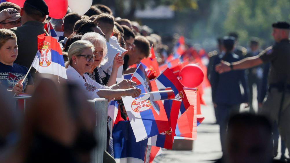 posetioci sa srpskim zastavama na vojnoj paradi