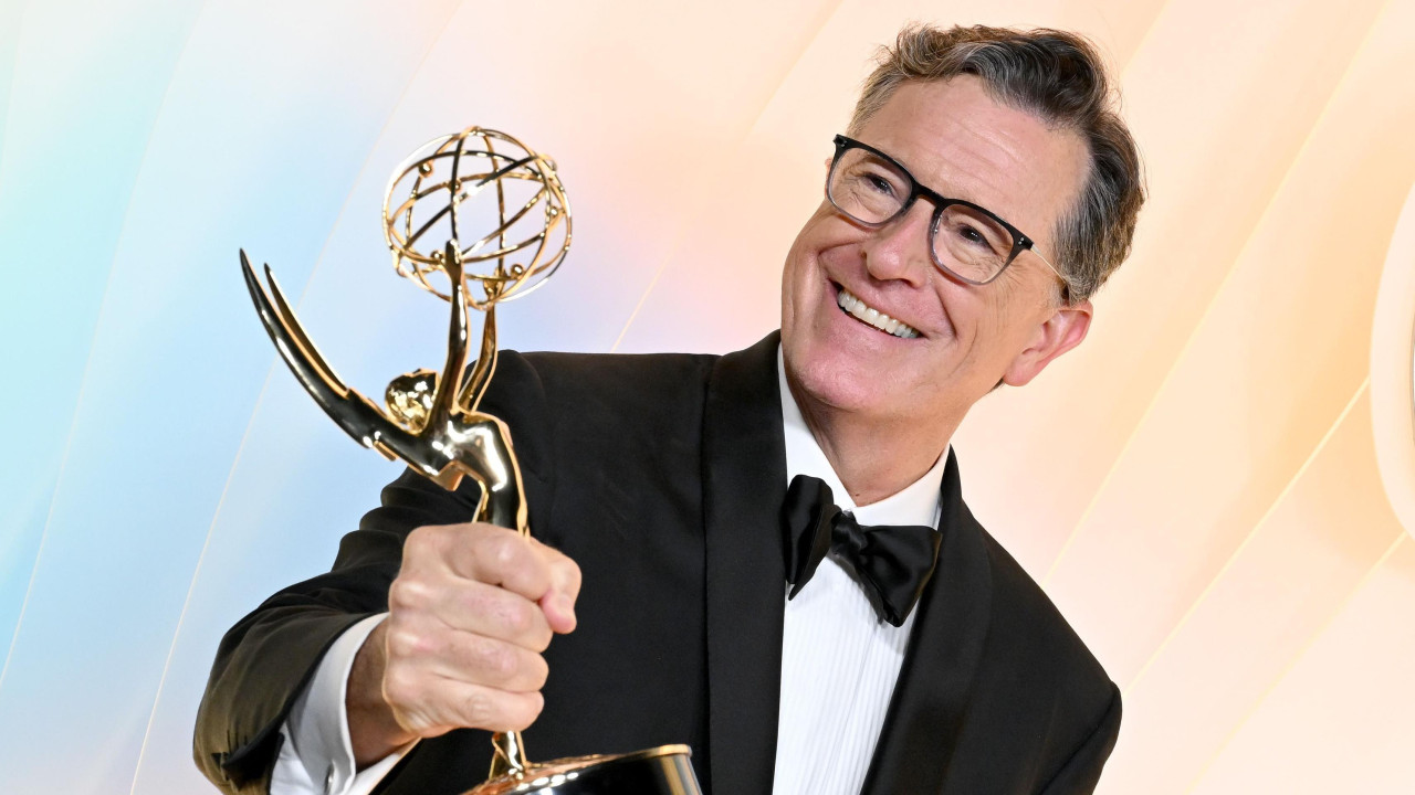 Stiven Kolbert u smokingu i uz veliki9 osmeh drži nagradu Emi