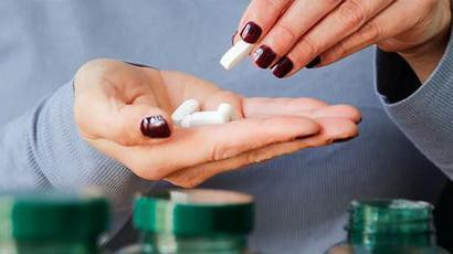 Šaka devojke puna tableta, ženska ruka puna tableta