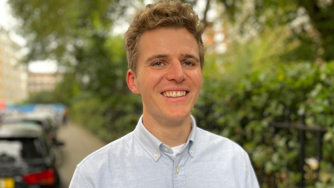 Nasmejani Džek Mej-Dejvis u svetlo-plavoj košulji