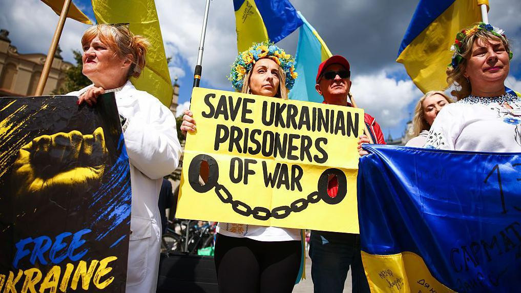 Ljudi drže transparente na kojima zahtevaju oslobađanje ukrajinskih ratnih zarobljenika, na jednom od njih piše „Slobodna Ukrajina“