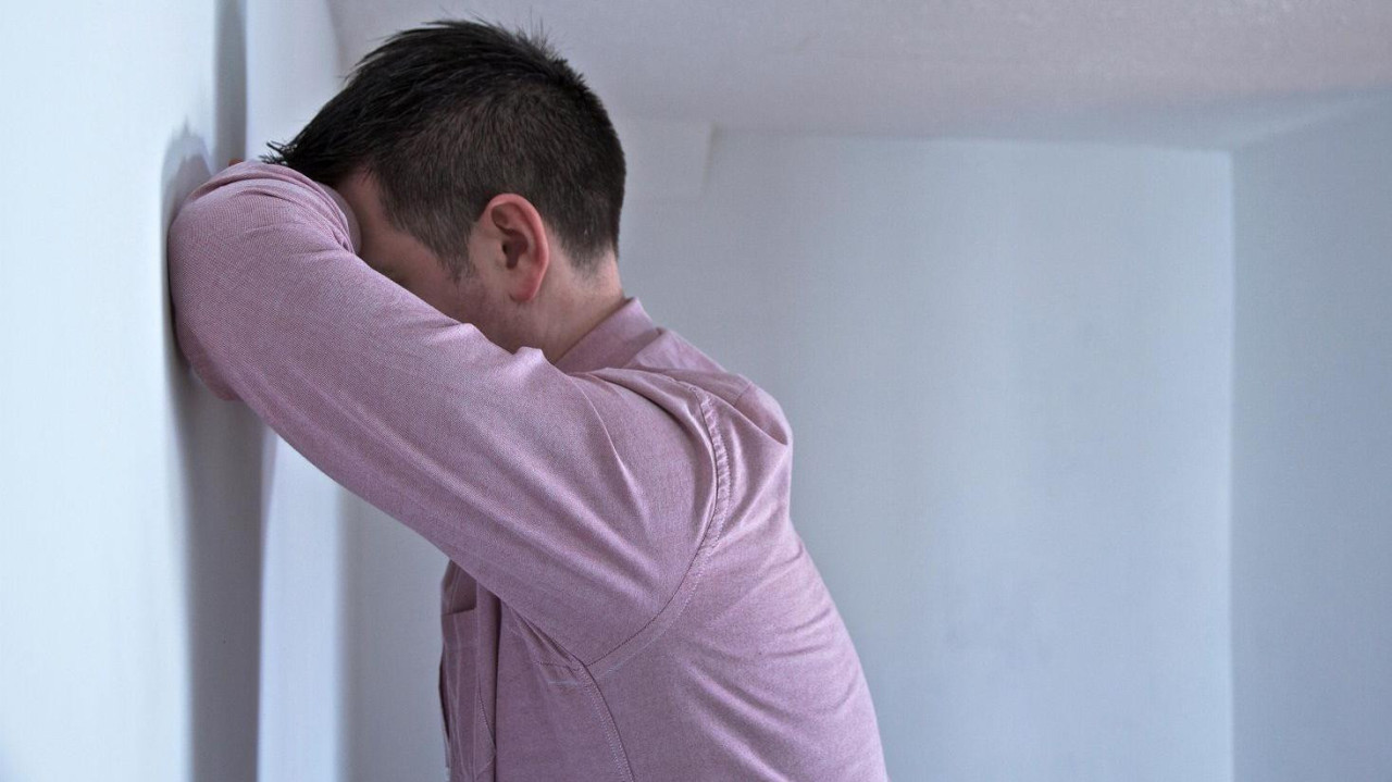 Čovek naslonjen na zid 